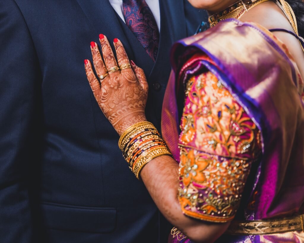 bride wearing traditional indian bangles during the wedding with her husband in closeup